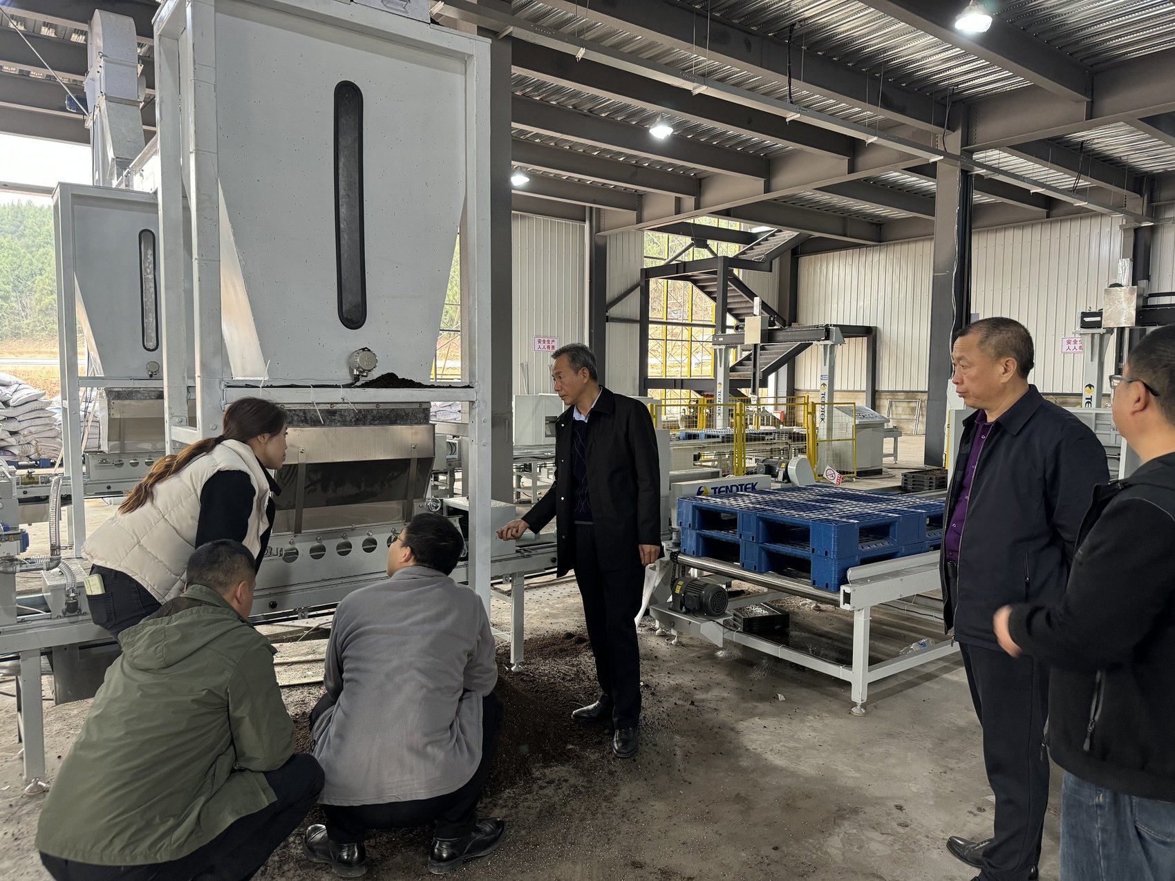 四川农业大学教授马均（右三）带着研究团队成员查看播种机流水线工作状况。