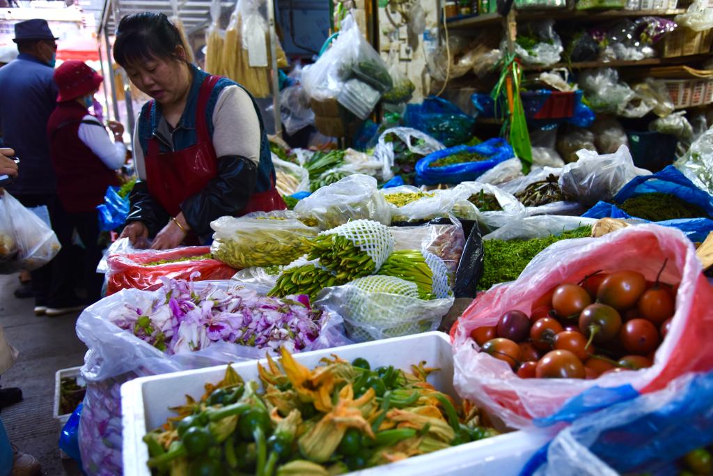 3月24日，昆明市大观篆新农贸市场一家卖时令野菜、野花的商铺。新华社记者熊轩昂 摄