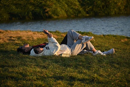     云南昆明某公园内年轻人躺在草坪上聊天。崔亚芹/摄