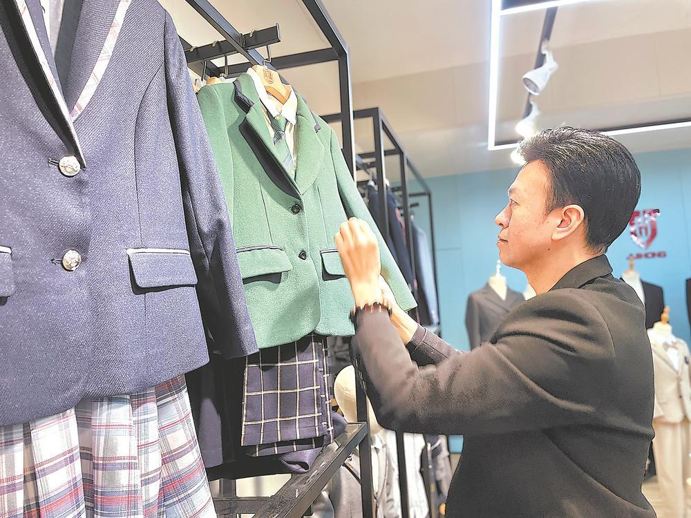郭锡加正在公司展厅打理英伦风校服.