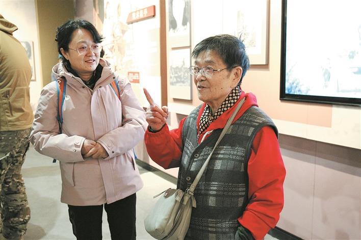 湘女刘玲玲（右）参观“天山芙蓉·八千湘女上天山”历史陈列，并给大家讲述过去的故事（摄于3月24日）。 赵林洁 摄