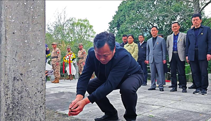 祭扫人员向烈士墓敬献家乡一抔黄土，缅怀烈士。（黄山区退役军人事务局供图）