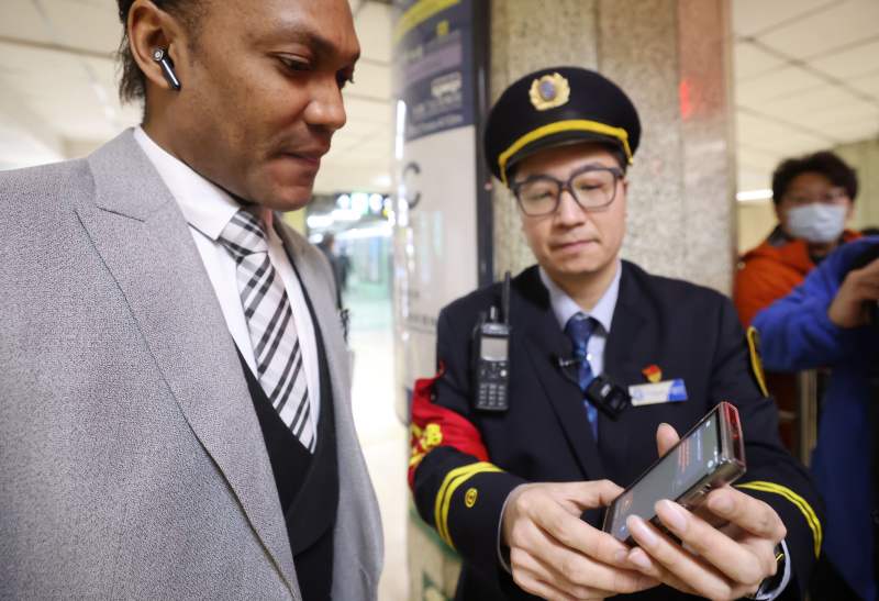 今天上午，地铁2号线东直门站，工作人员通过翻译机向一位外籍乘客告知出行线路。新京报记者 王贵彬 摄