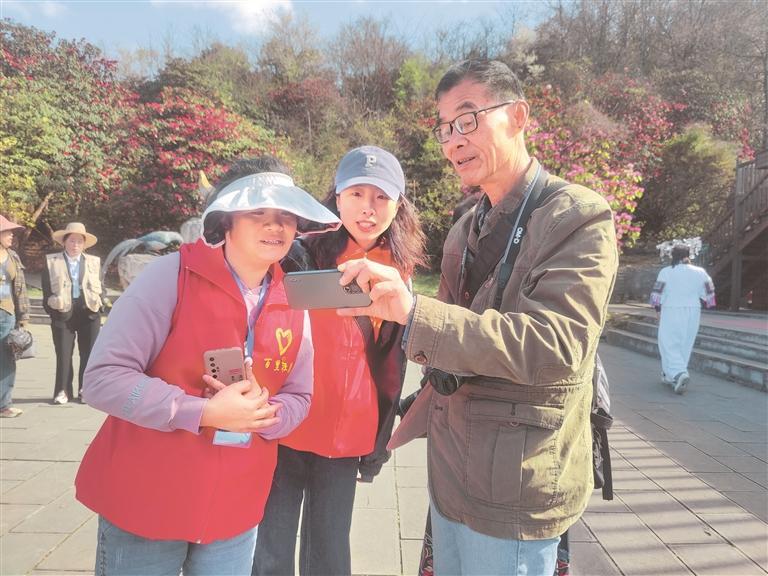党员志愿者在金坡景区为游客提供咨询服务. 汪沙 摄