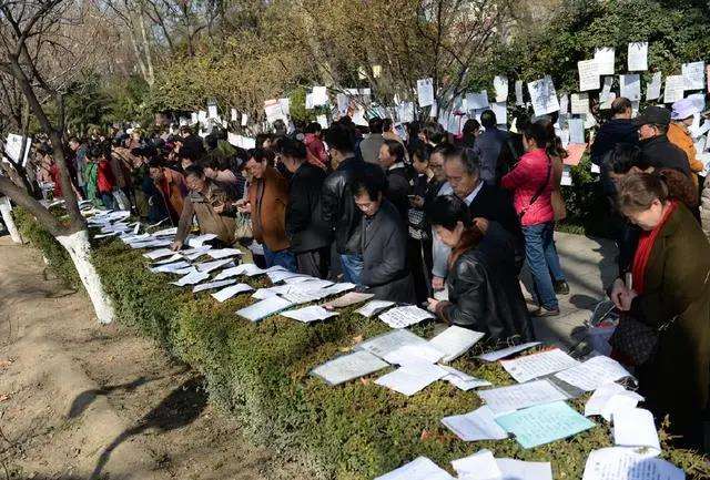 资料图:某地市民在公园相亲角浏览征婚信息.图/新华社