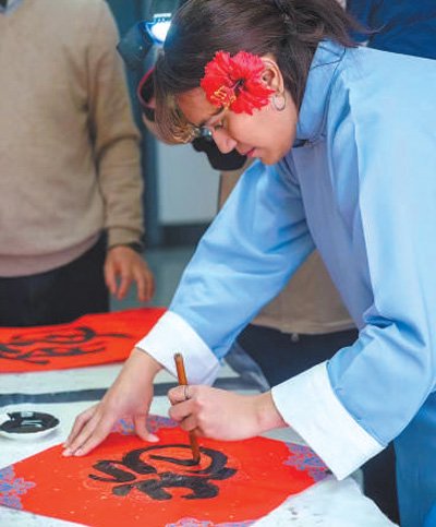 　　安雅在学校为留学生举办的新春活动上用毛笔书写“福”字。受访者供图