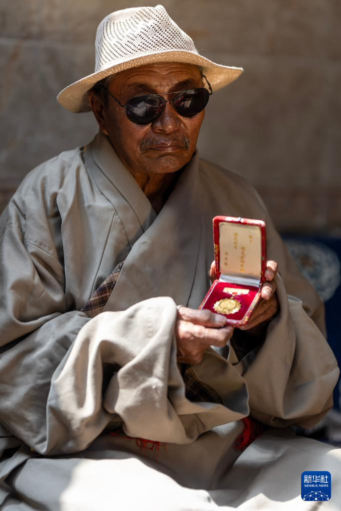 白玛老人展示自己的全国劳动模范奖章(3月27日摄).新华社记者 姜帆 摄