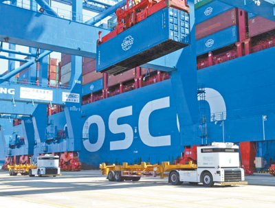 无人驾驶集装箱卡车正在中远海运港口阿布扎比码头作业。