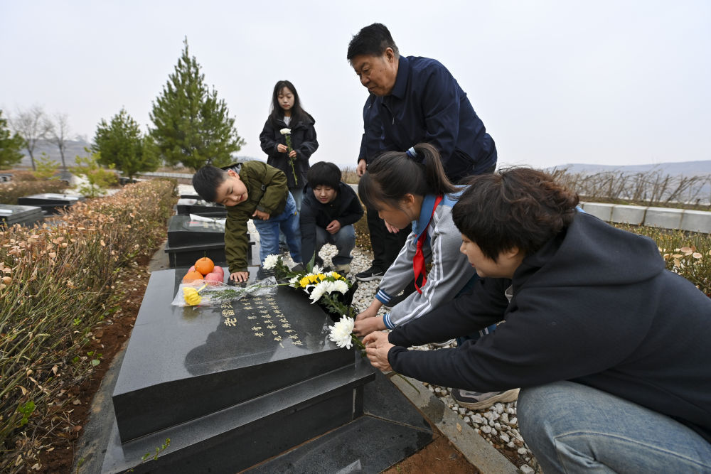 4月3日,在位于武乡县里庄村的八路军烈士陵园,梁效珍一家为烈士献花.