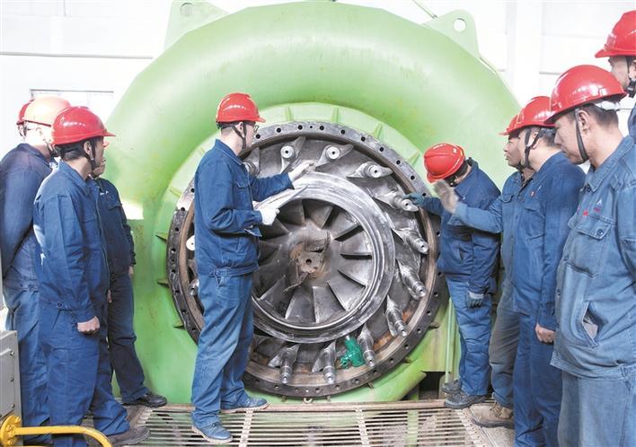 3月23日，在新疆锦龙电力集团有限公司新北水电三级站厂房内，党员技术攻关小组的队员们在排查设备故障。朱建华 摄