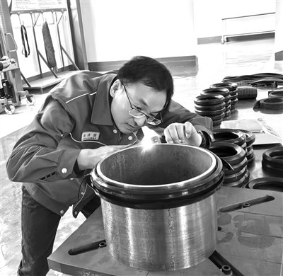 图为科研人员对井口套管头用关键密封件进行检测。(仇国贤 摄)