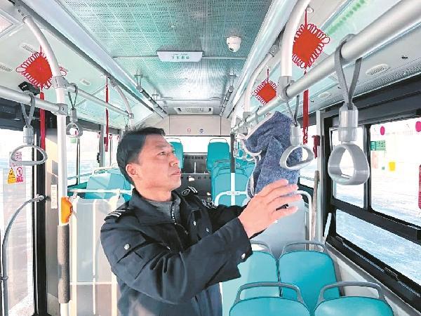 3月17日，王子强在擦拭公交车上的扶手，为乘客提供舒适整洁的车厢环境。 齐琳洁 摄