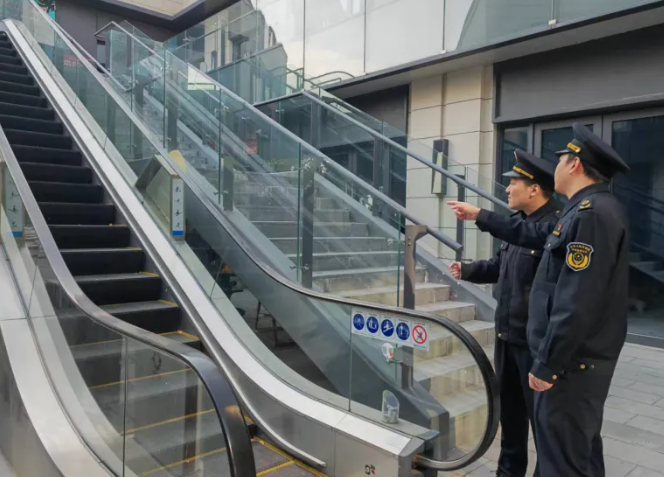 ▲松江区市场监管局执法人员检查自动扶梯防攀爬装置设置情况