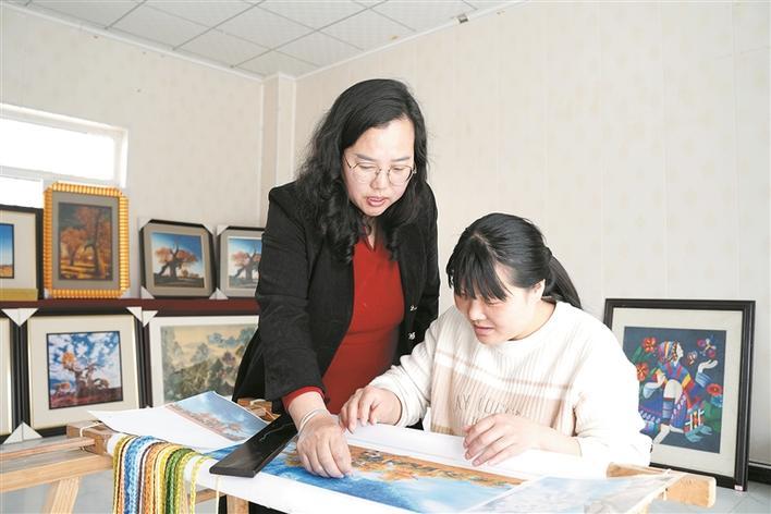 4月3日,在一师阿拉尔市文化(图书)馆,刘琴创作塔河民间刺绣作品.