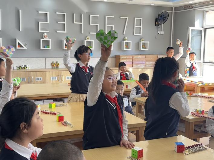 同学们正在展示拼好的"爱心"状魔尺.