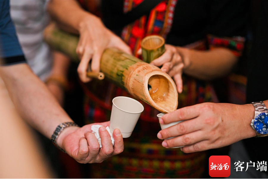 黎族同胞为宾客送上迎宾酒——黎族特色山兰酒.
