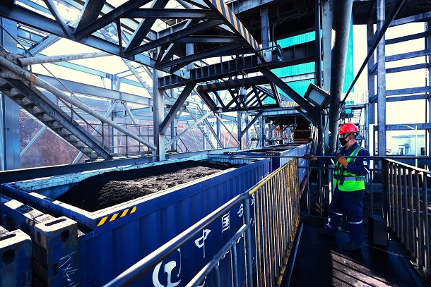图为新疆准东煤矿火车快装站工作人员开展平煤作业