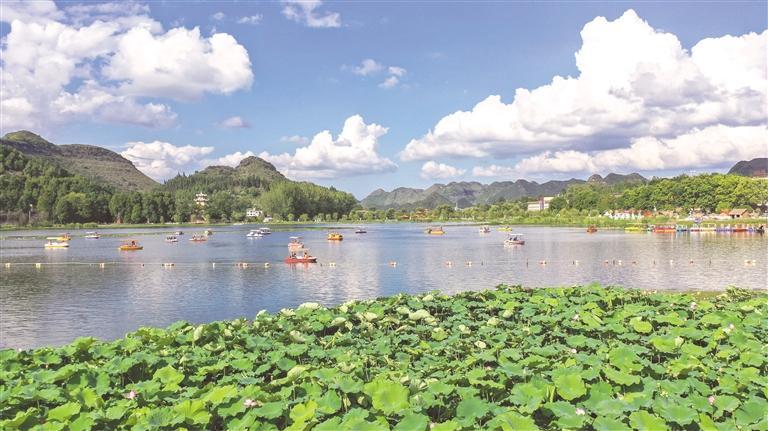 游客在安龙县招堤国家湿地公园乘船游玩。 刘朝富 摄