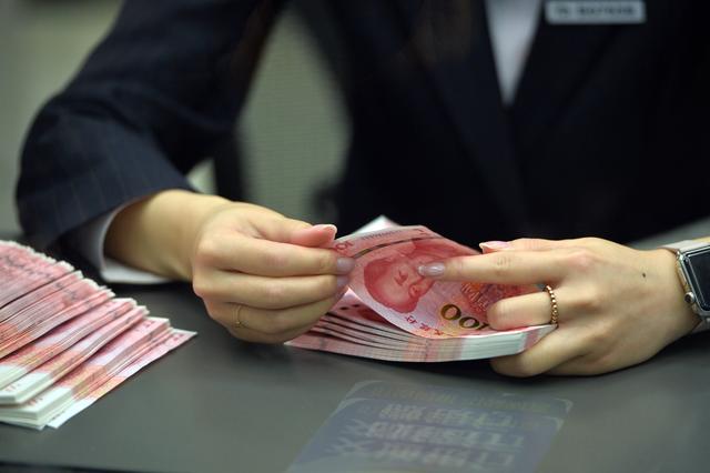 图为一名银行工作人员在清点钞票。 新华社记者李鑫 摄