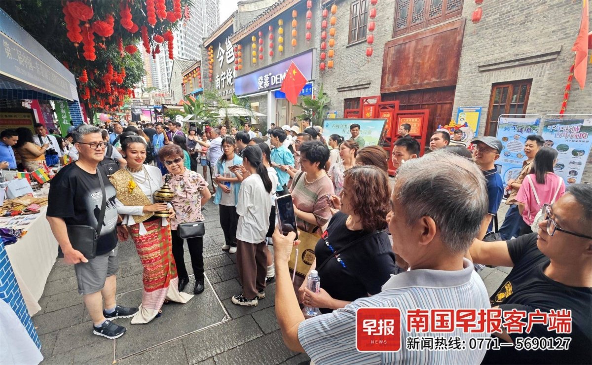 游客与东南亚风情表演者合影.记者&nbsp;何定坚 摄