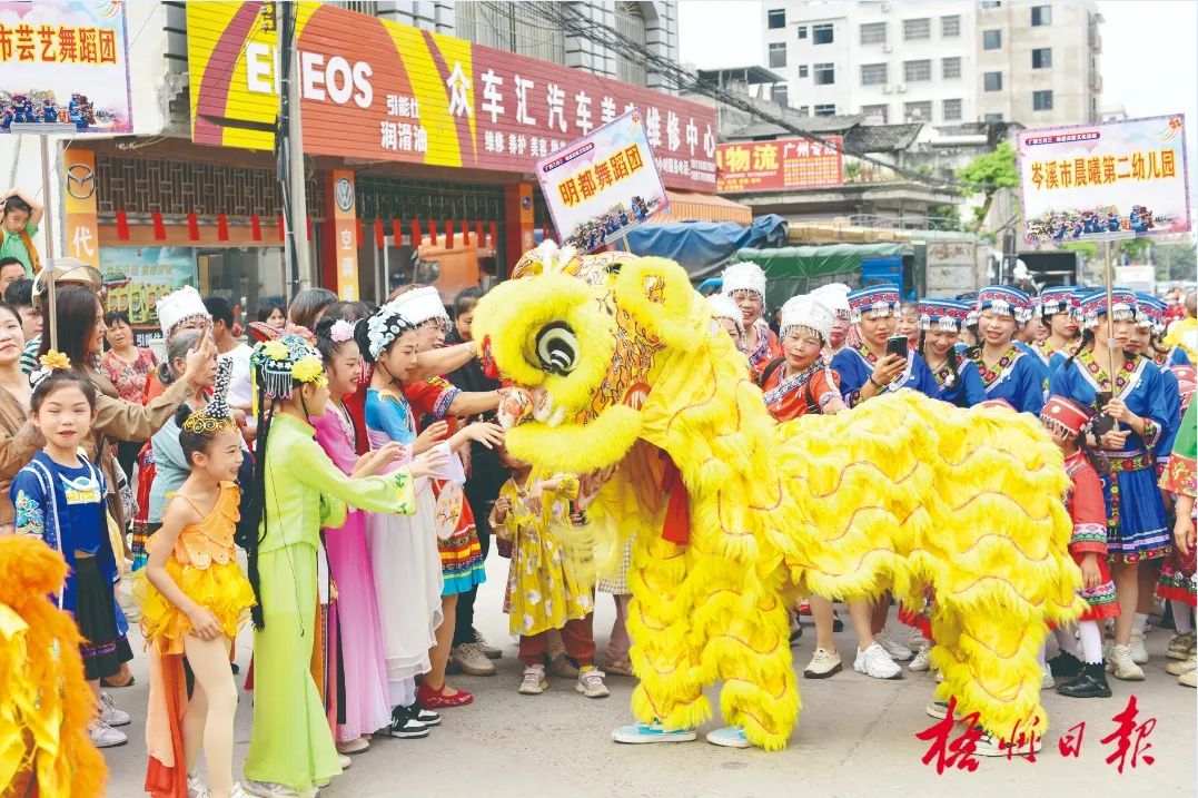 4月11日，在樟木古街入口处，龙狮正在与孩子们互动。李灿明 摄