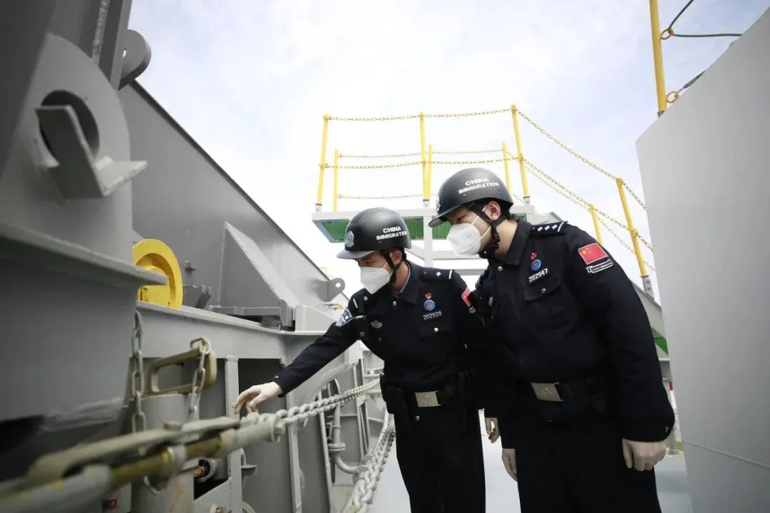 图1为该船开航航拍;图2为江苏边检总站启东边检站移民管理警察登船