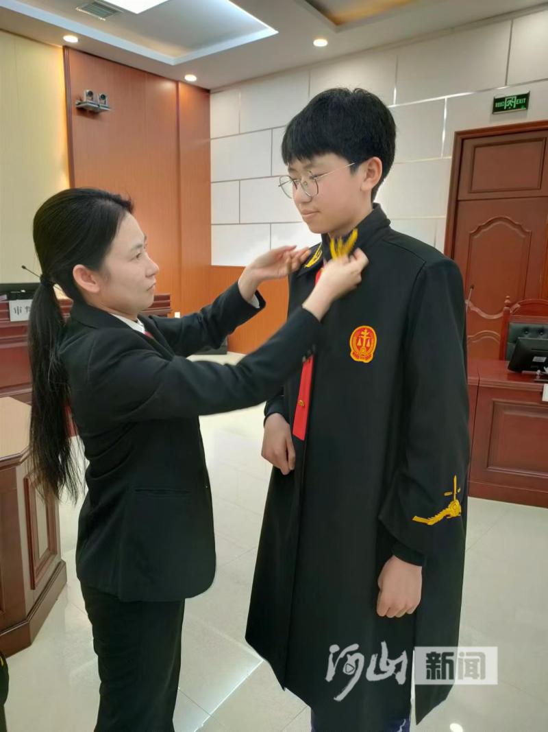 王慧慧正在给试穿法袍的同学整理衣领&nbsp; 荆丽娟 摄