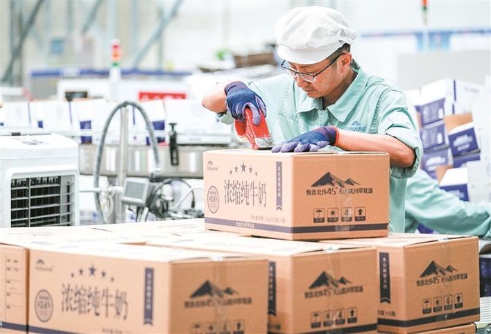 在新疆天润乳业股份有限公司生产车间内，工人在把乳制品密封装箱（资料图片）。田园 摄