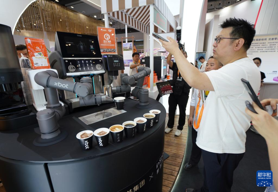 4月15日，在第四届消博会王府井集团展台，xbot拉花咖啡机器人为参观者制作咖啡。    新华社记者 李梦娇 摄 