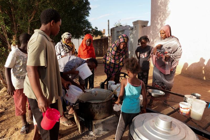 当地时间2024年4月6日，苏丹恩图曼，苏丹难民等待慈善厨房分发的食物。图/IC photo