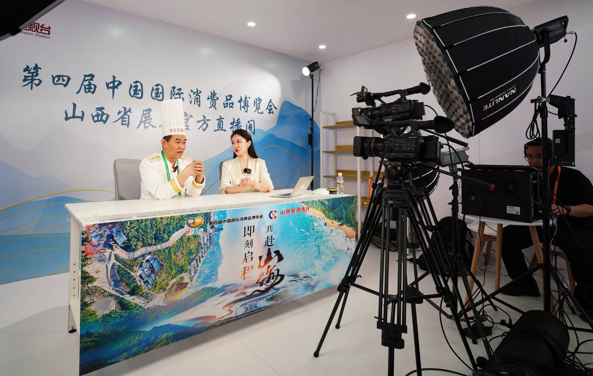 4月13日,在消博会山西省展台官方直播间,晋菜厨师王力群(左)通过直播