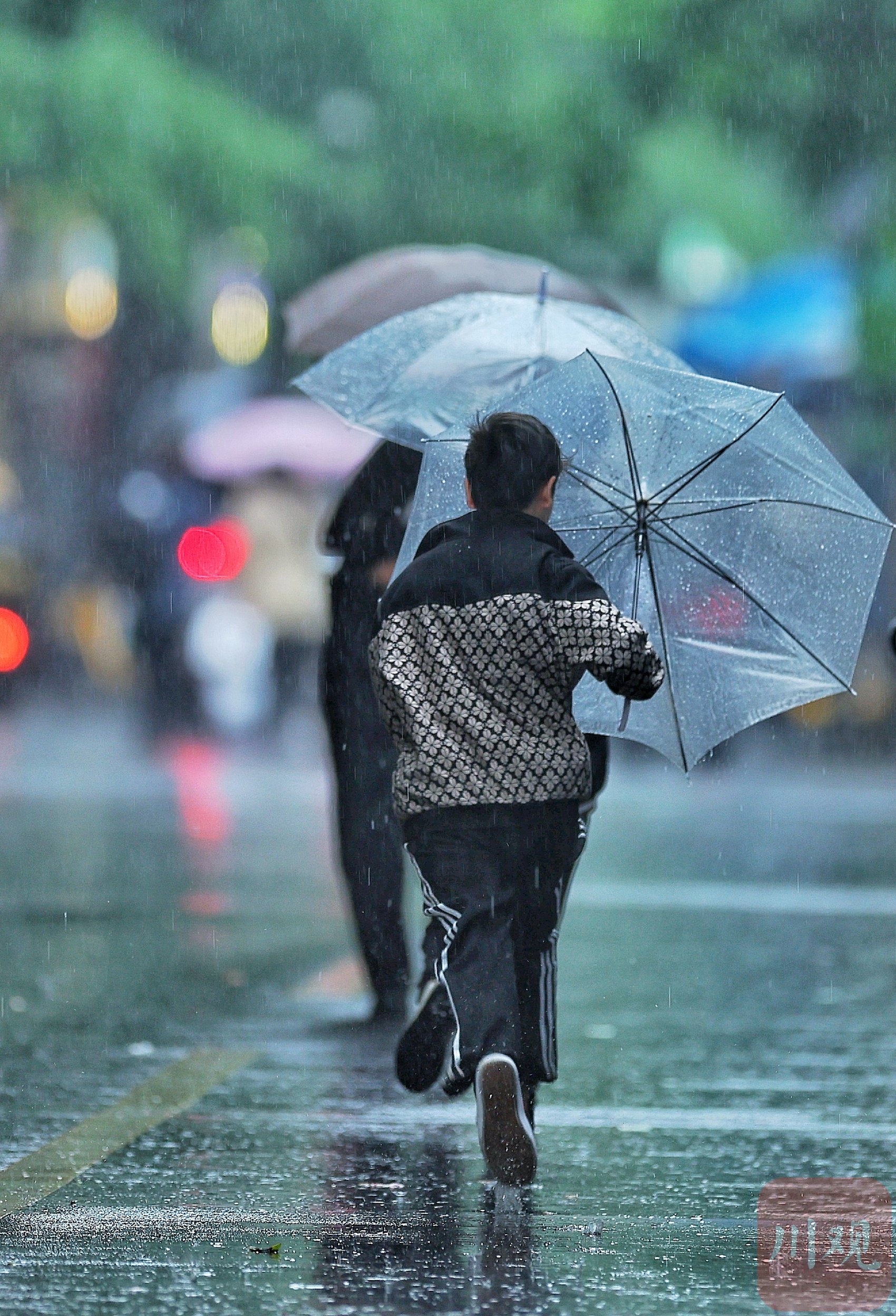 打伞在雨中奔跑的市民