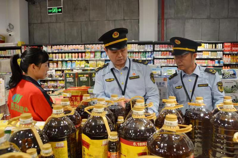 图为4月17日，执法人员在一家超市检查食用油质量。（文光辉 摄）