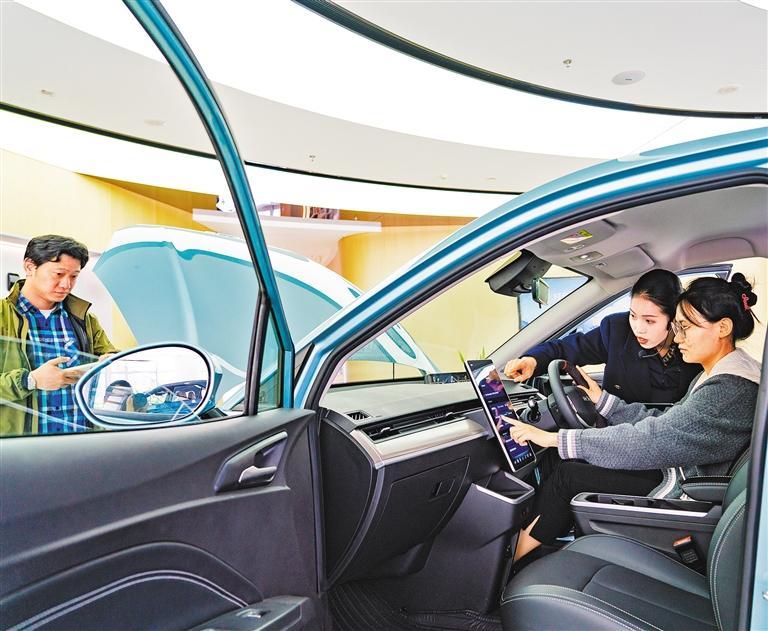 ▲4月1日，位于上海市普陀区的哪吒汽车全球总部展示大厅，工作人员在介绍新款车型。哪吒汽车全球总部去年在上海普陀区启用。