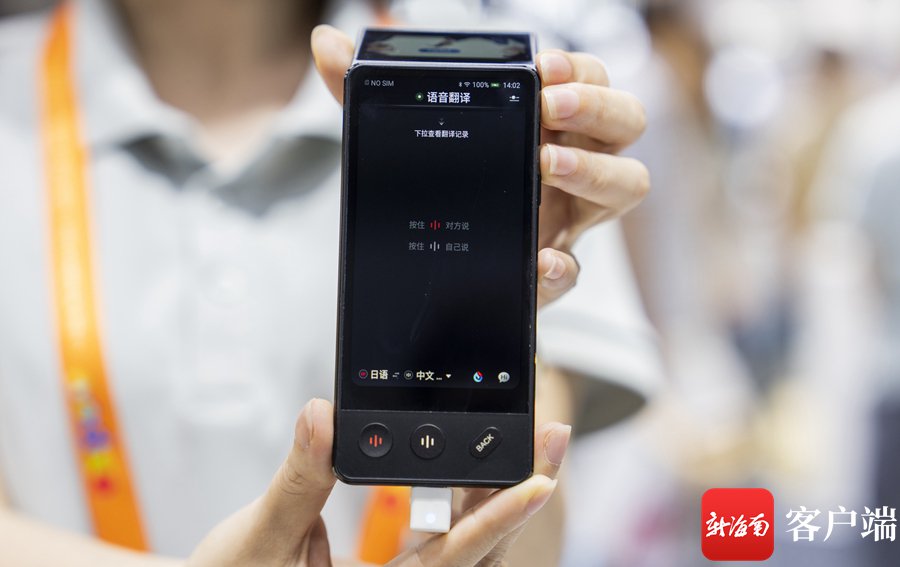 科大讯飞展台,工作人员展示科大讯飞双屏翻译机.记者 李昊 摄