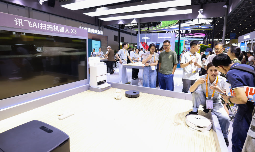 ↑4月17日，参观者在科大讯飞展台参观了解讯飞AI扫地机器人，此品牌是第四次参展消博会。 新华社记者 杨冠宇 摄