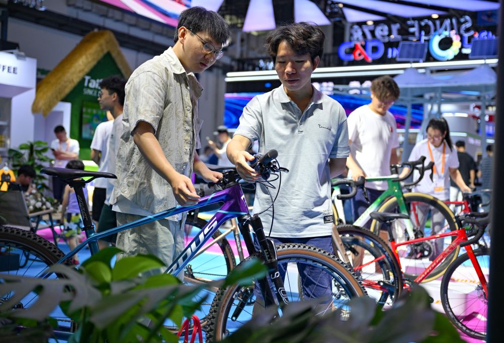 ↑4月17日，参观者在泰山体育展台参观自行车，此品牌是第四次参展消博会。 新华社记者 郭程 摄