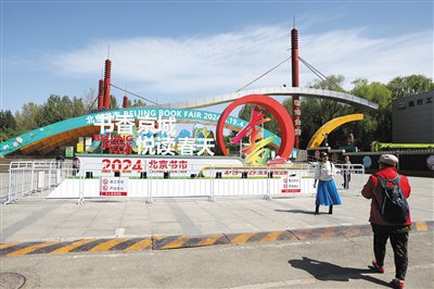 4月18日，朝阳公园，市民在北京书市前留影。本版摄影/新京报记者 浦峰