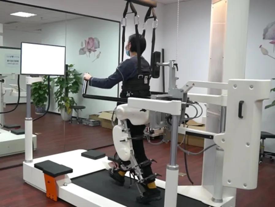 图为患者正在借助康复机器人进行训练。