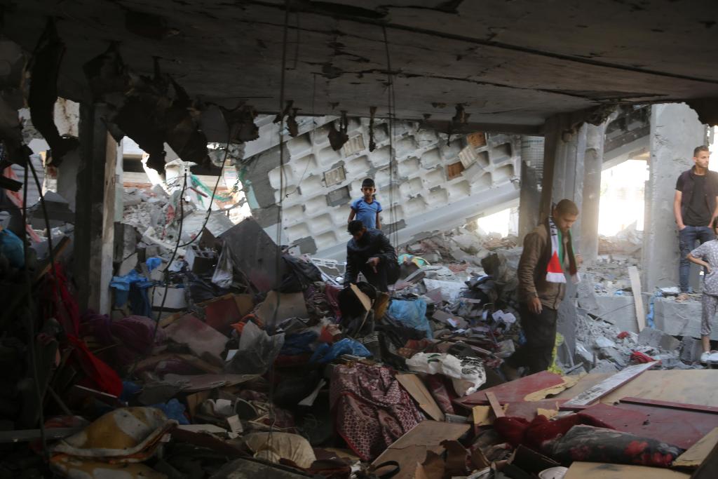 4月17日，在加沙南部城市拉法，人们查看遭以军空袭的住宅废墟。新华社发（哈立德·奥马尔摄）