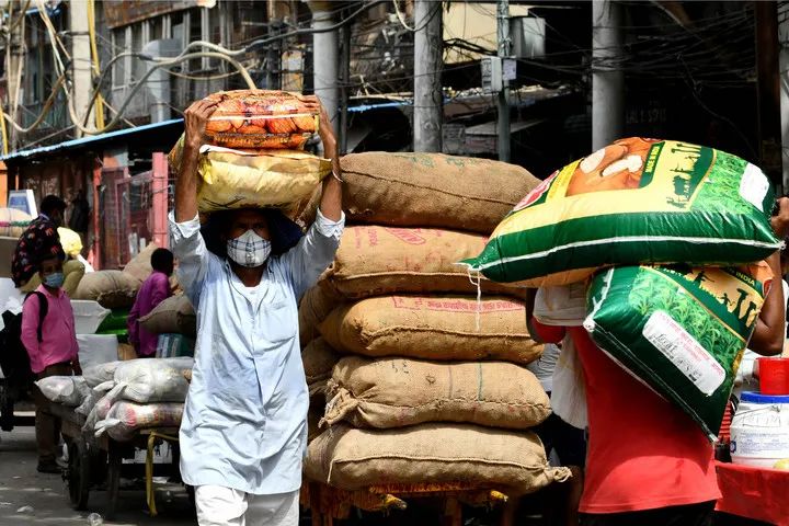 2021年6月9日，工人在印度德里的街头搬运物资。新华社发（帕塔·萨卡尔摄）