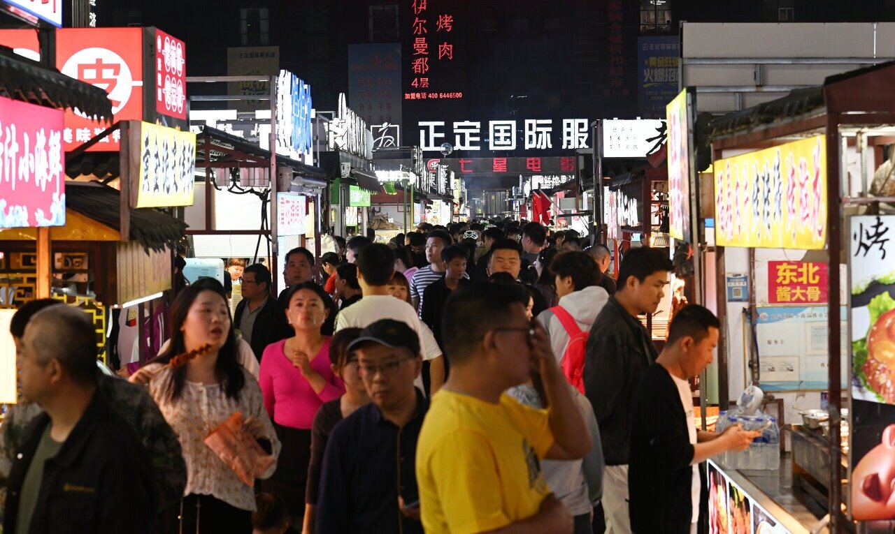 4月16日，正定小商品夜市人头攒动，游客在购买各色美食。 河北日报记者史晟全摄