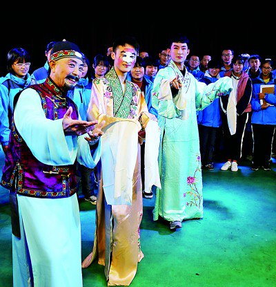 沾化区第一中学学生向沾化渔鼓戏剧团国家一级演员王增旭(左一)学习