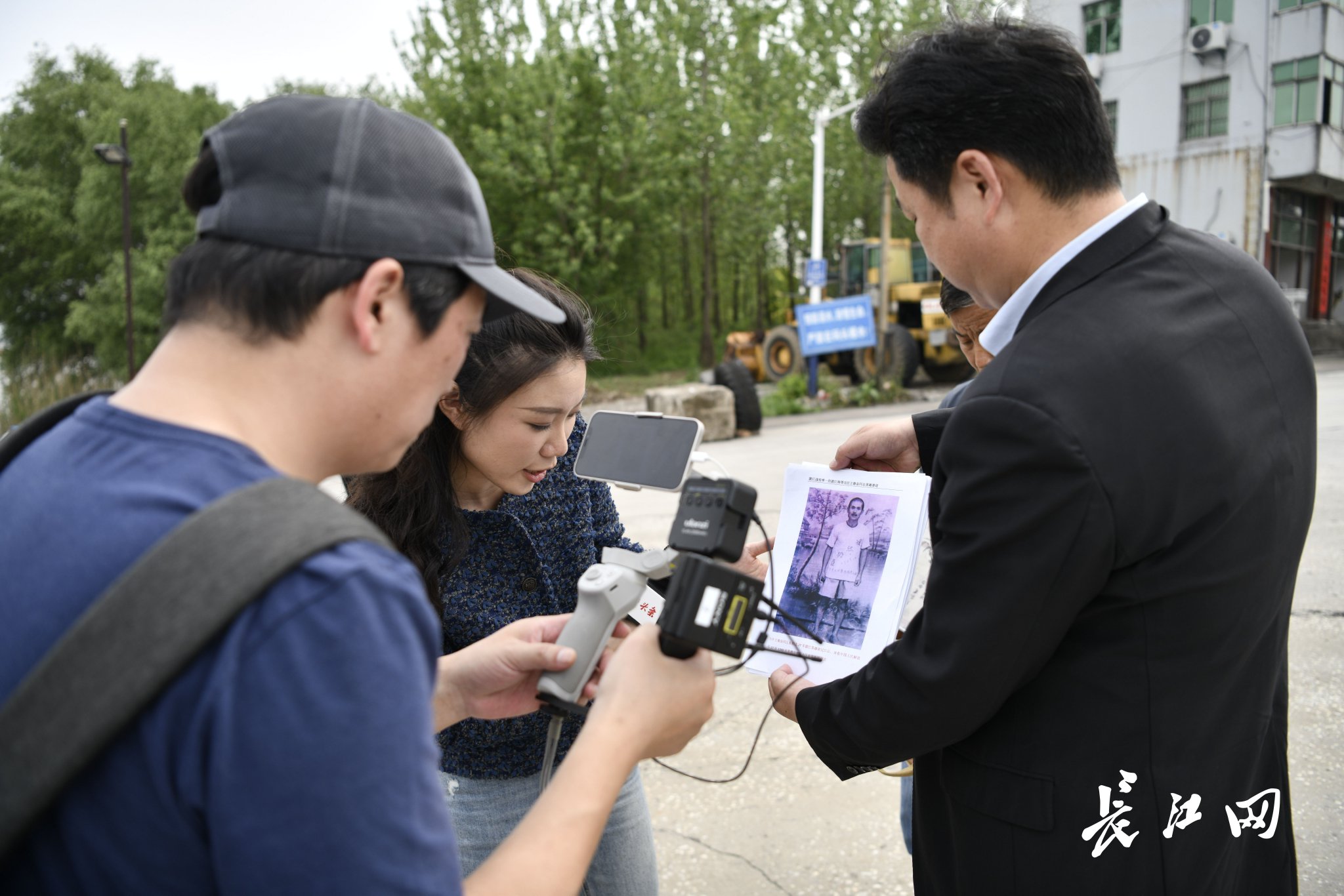 王玉斌（右一）在直播中展示王德金同志英雄事迹。长江网记者吕诗文 摄