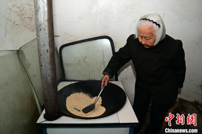 103岁的鞠兰英正在炒米茶。刘康 摄