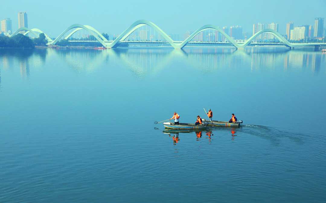 4月22日,河南省南阳市白河湿地公园,工人在打捞河面上的漂浮物.