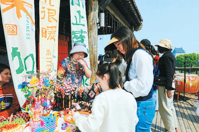 市民游客了解非遗手工制品.
