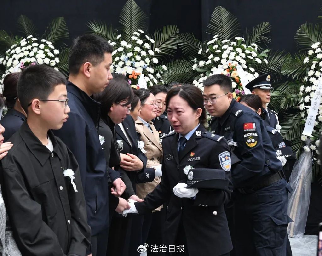 图为追悼会现场悼念大厅里,礼兵肃立,庄严肃穆,大厅正中央悬挂着武霖