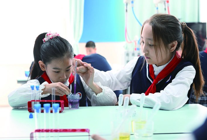 科学实验室内，一堂科学课正在进行，同学们亲手做液体分层实验。 赵滨 摄
