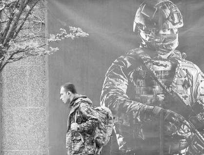 　　当地时间2024年4月23日，乌克兰基辅，一名军人走过征兵海报。视觉中国供图